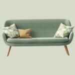 a green couch with two pillows on it