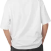 A man seen from the back wearing a white oversized t-shirt and black pants. Shows the relaxed fit and drape of the t-shirt.