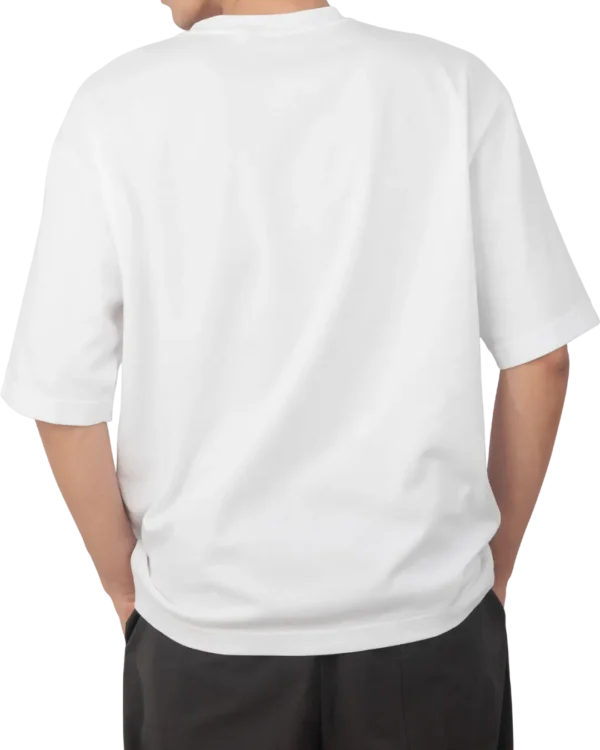 A man seen from the back wearing a white oversized t-shirt and black pants. Shows the relaxed fit and drape of the t-shirt.
